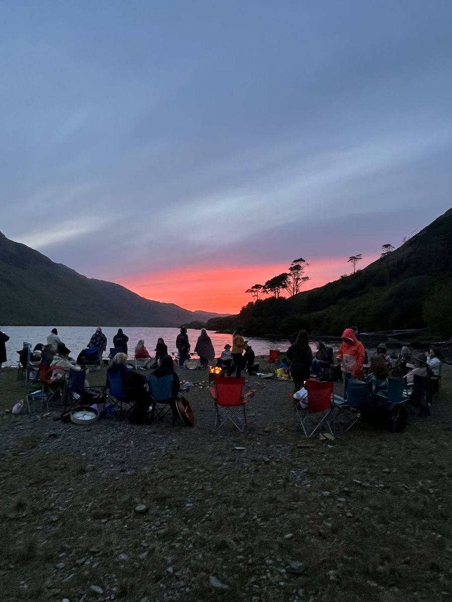 Ceremonia de fuego al atardecer junto a un lago