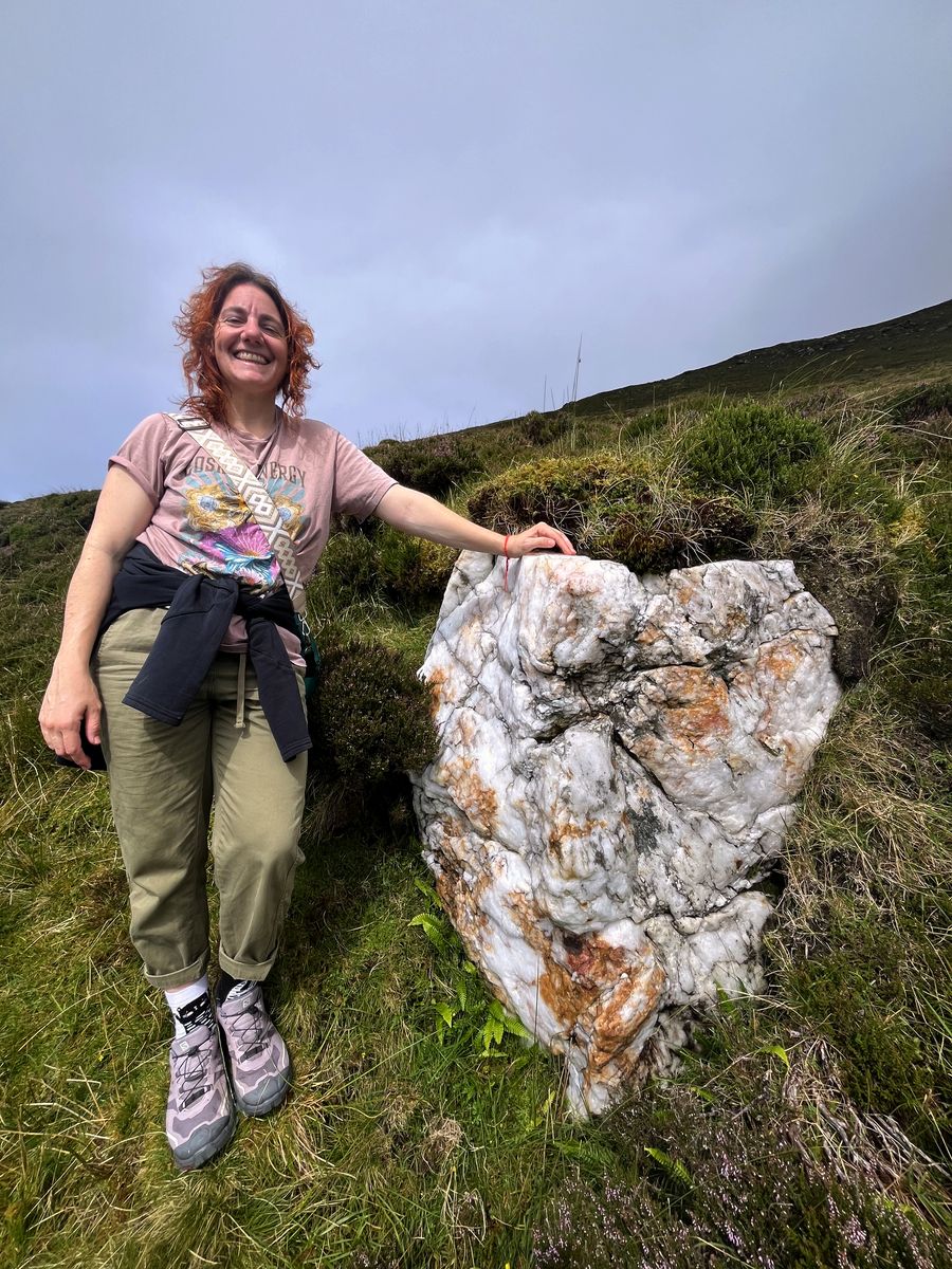 Nela junto a una piedra grande en la montaña